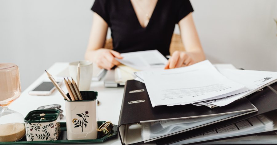 How to read tender documents - an image of a lady with lots of documents and files on her desk