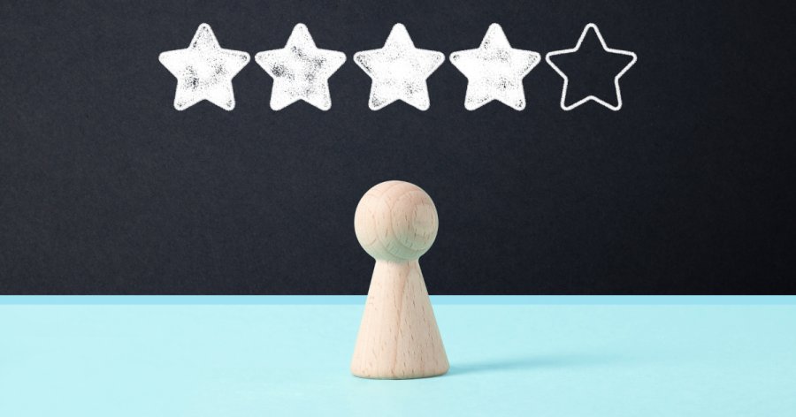 An image to represent tender scores with two colours as background - black on the top, blue on the bottom. 5 stars representing the score with 4 coloured in, and a wooden pawn-like chess piece in front of the score representing a person.