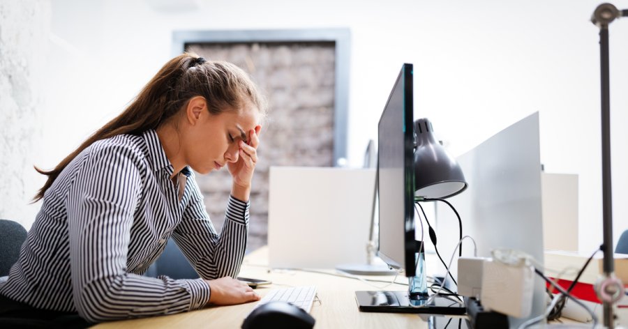 Women sitting at her desk, head in hands, frustrated that a tender has been withdrawn